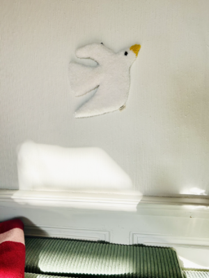 Tapis mural en tufting représentant une mouette. Finitions sculptées et dos antidérapant. Attache en métal noir pour une pose facile. Disponible sur mesure.